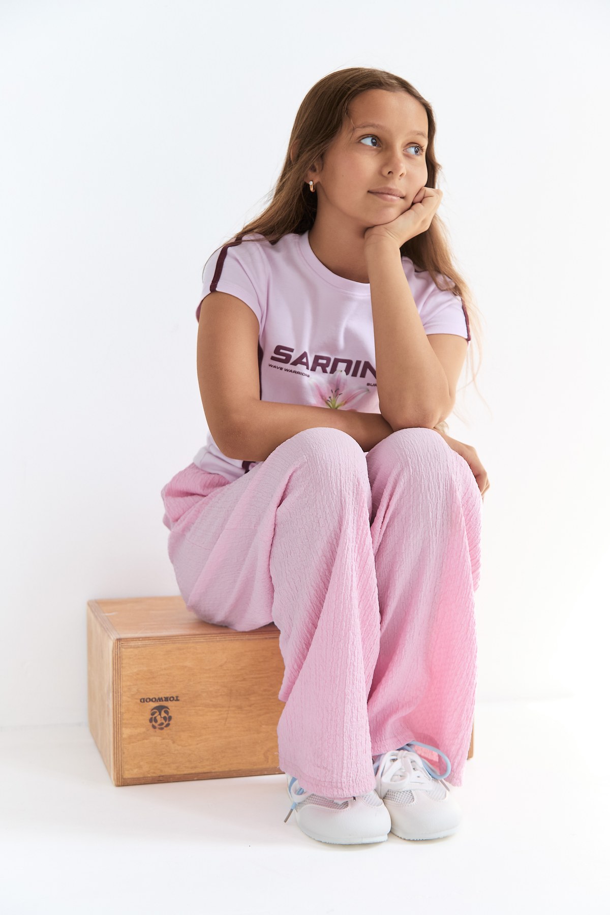 Thoughtful seated portrait in a pale pink outfit