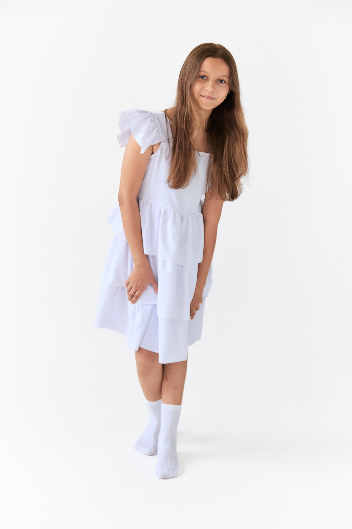 Full-length portrait of Kira in a white tiered dress